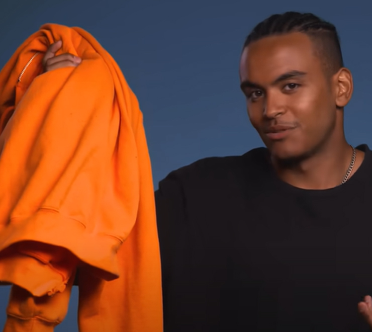 Une jeune personne tenant une chemise orange