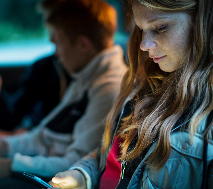 Un·e adolescent·e regardant son téléphone portable